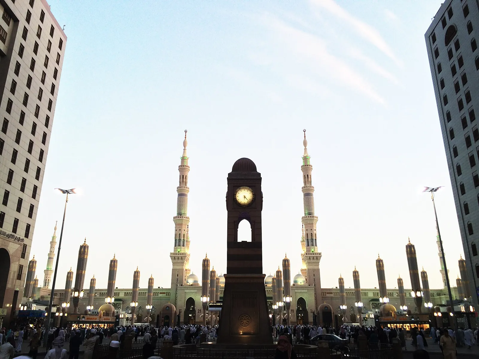 Pelataran Masjid Nabawi di Madinah dengan menara dan payung raksasa di sore hari
